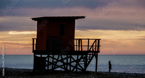 Silhouette of a lifeguard tower on the sunset beach
