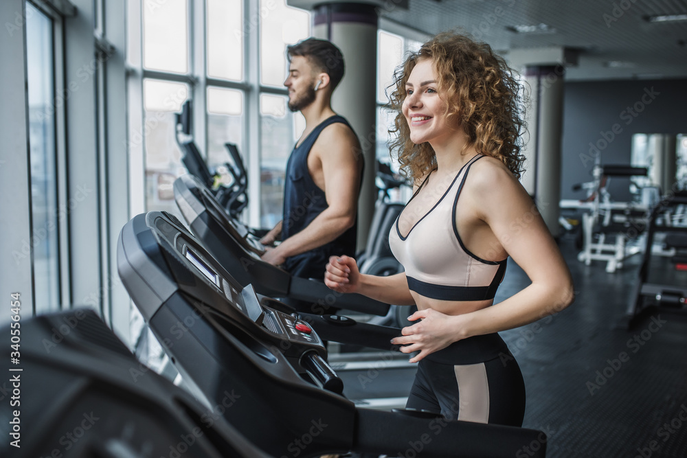 Young sports couple making cardio workout in modern gym Young sports couple making cardio workout in modern gym