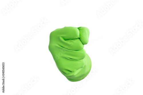 Hand with green rubber protective glove gesturing punch, the fist, isolated on white. Signs of gestures (language), gloves cleaning, kitchen gloves. photo