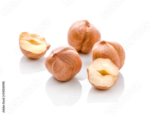 Full and halfs of hazelnuts on white background. Isolated