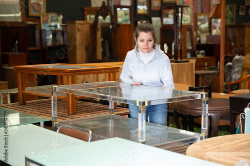 Woman looking for glass coffee table in store