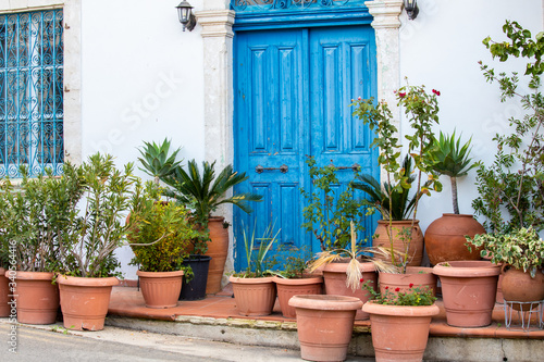 beautiful old blue door with lots of ceramic pots with plants in traditional villages of Cyprus and the Mediterranean