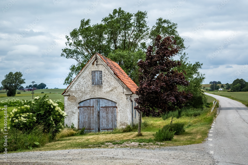 Old weathered brick shed with plaster peeling off next to a small country road in Valleberga, Skane, Southern Sweden. Old weathered brick shed with plaster peeling off next to a small country road in Valleberga, Skane, Southern Sweden.