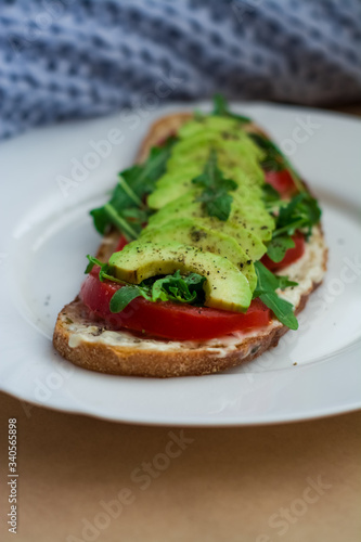 Toast of dark bread  avocado with tomato and arugula. Healthy food  breakfast of fresh vegetables.