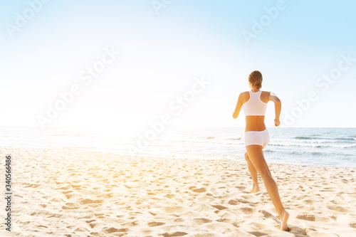 Woman Running on Sunny Sea Beach, Rear Back View, Girl in White Sexy Sport Clothes Jogging on Coast