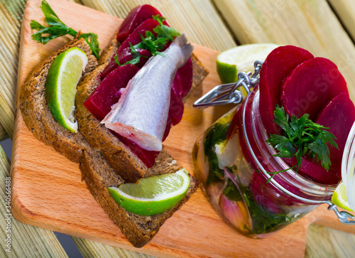 Marinated  poutassou served at bread with beets, onions and marinade from lime juice photo