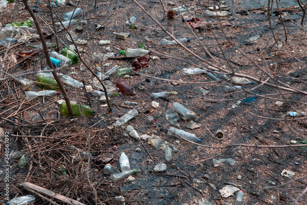 Obraz premium plastic bottles and other rubbish in river water. pollution of the oceans and the environment. dirty lake water