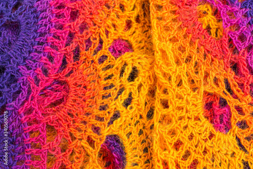handmade crochet background in yellow, orange, pink and purple