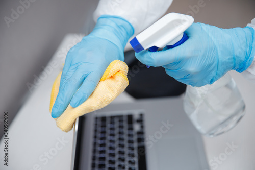 Cleaning service disinfects office, antiseptic processing of computer from coronavirus and germs