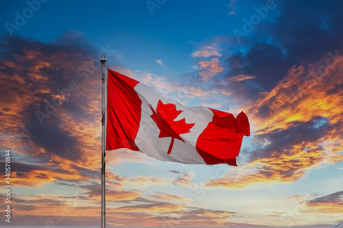 Foto Red and white Canadian Flag Flying at Sunset