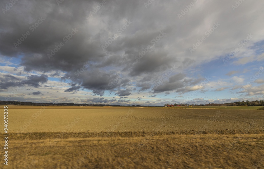 Beautiful nature landscape view on a spring day. Plowed field merging with blue sky and rain clouds. Beautiful nature landscape view on a spring day. Plowed field merging with blue sky and rain clouds.