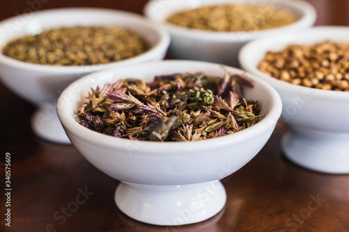Selective focus on the bowl with aromatic herbs between other products