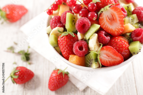 bowl of mixed fresh fruits- berry fruit  orange  kiwi and banana