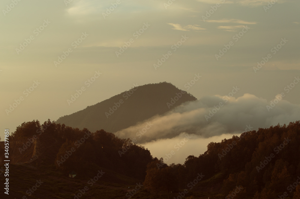 View of the Lewotobi Volcano Indonesia, with forest and clouds rising. Flores Island, Indonesia View of the Lewotobi Volcano Indonesia, with forest and clouds rising. Flores Island, Indonesia