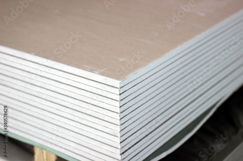 A stack of drywall sheets. Warehouse or shop of building and decoration materials. Wholesale or retail sale. Logistics and warehousing.