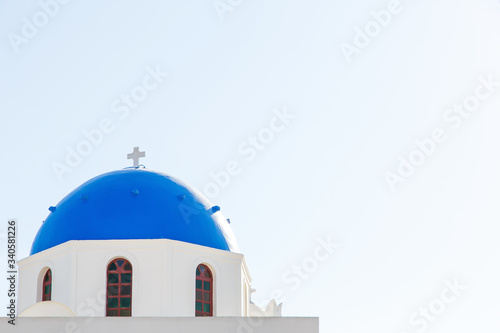 Famous blue dome churches in Oia, (Santorini, Greece) in the morning. White architecture of Oia village on Santorini island, Greece. Traditional tourism in mediterranean white architecture view