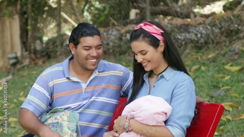 Portrait Young Hispanic Couple With Newborn Baby at The Park photo