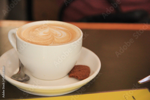 Amsterdam, Netherlands - July 12 2018: Coffee cup with cookie and spoon on a restaurant table