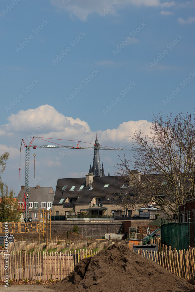 church tower and crane in the city under a sky full of clouds