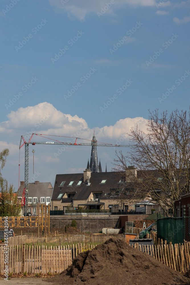 church tower and crane in the city under a sky full of clouds church tower and crane in the city under a sky full of clouds