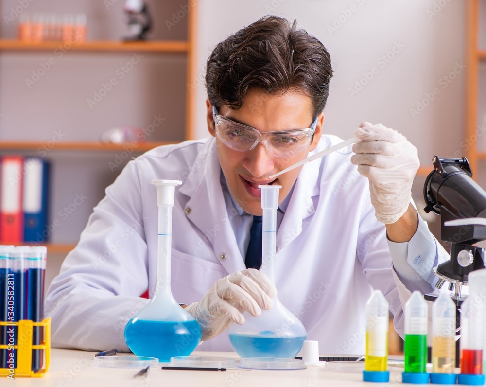 Young handsome biochemist working in the lab Young handsome biochemist working in the lab