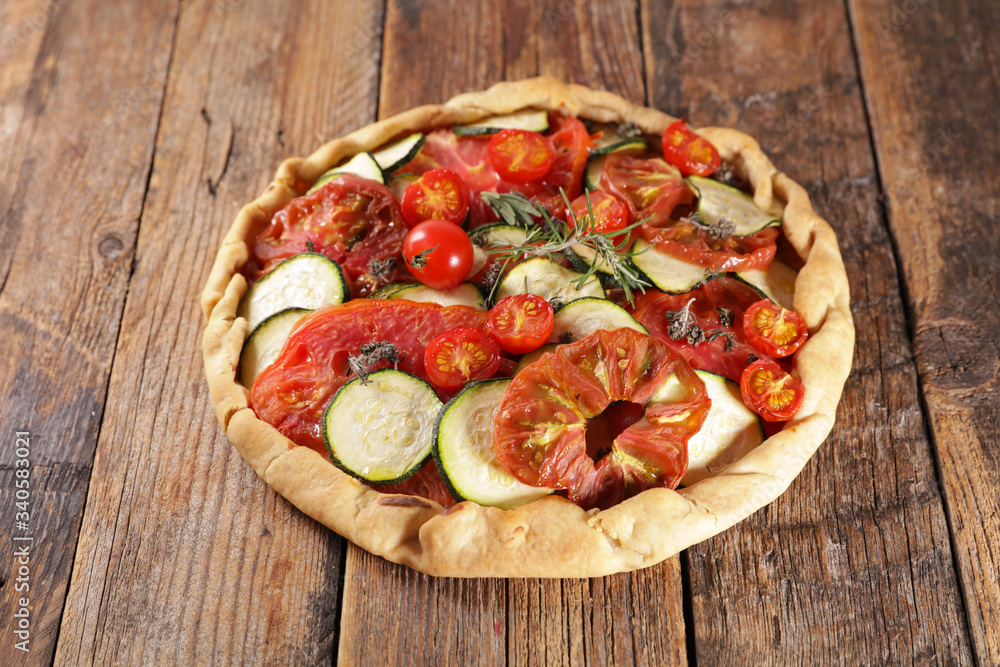 vegetable quiche with rosemary on wood background vegetable quiche with rosemary on wood background