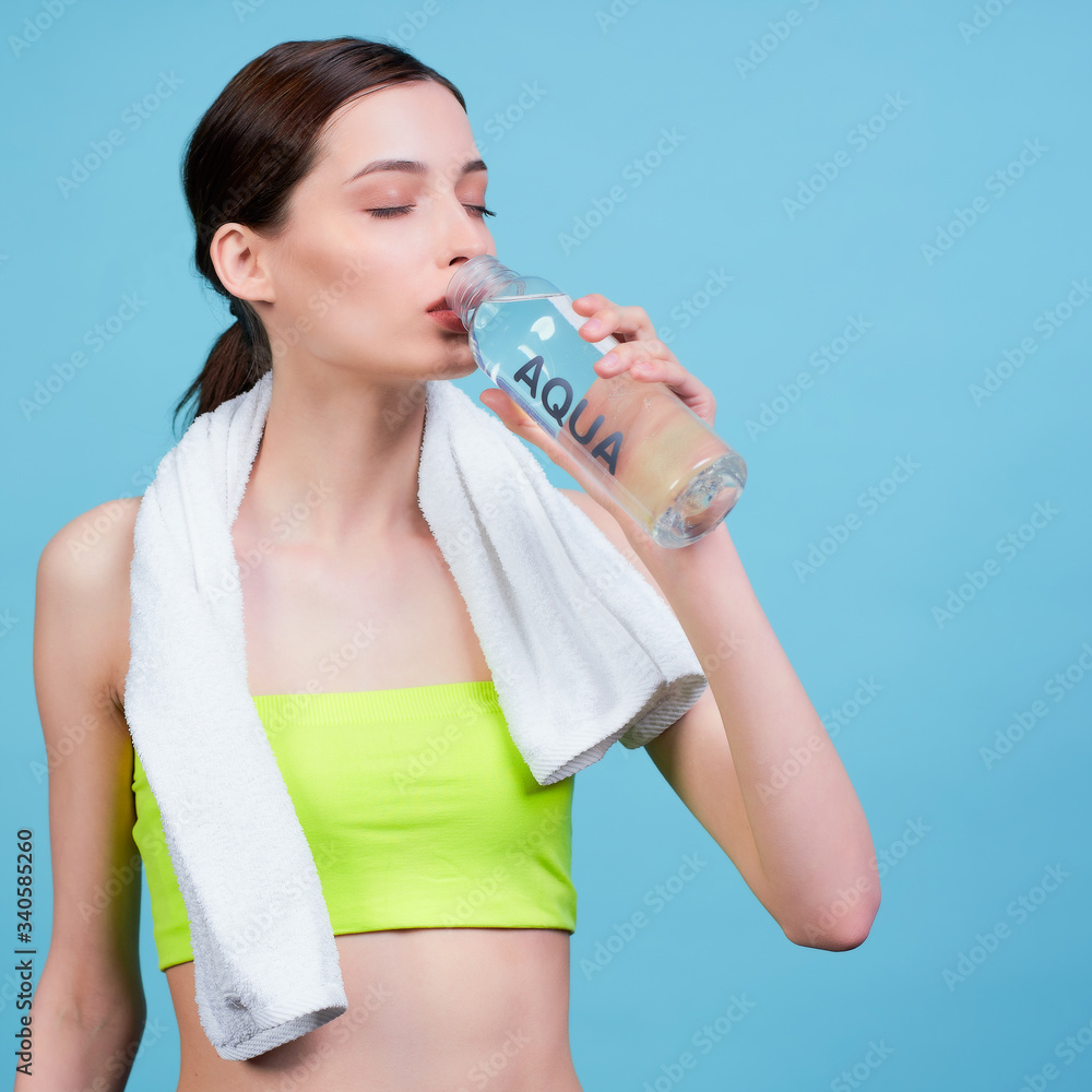 Nice girl after training drinks water from a bottle. Nice girl after training drinks water from a bottle.