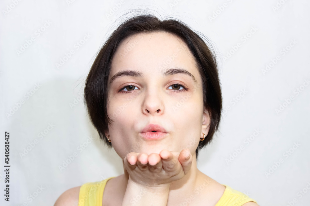 A close up brunette girl blows a kiss. A close up brunette girl blows a kiss.