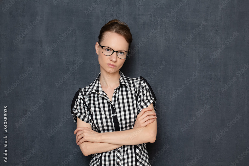 Portrait of serious focused woman with glasses, holding arms folded Portrait of serious focused woman with glasses, holding arms folded
