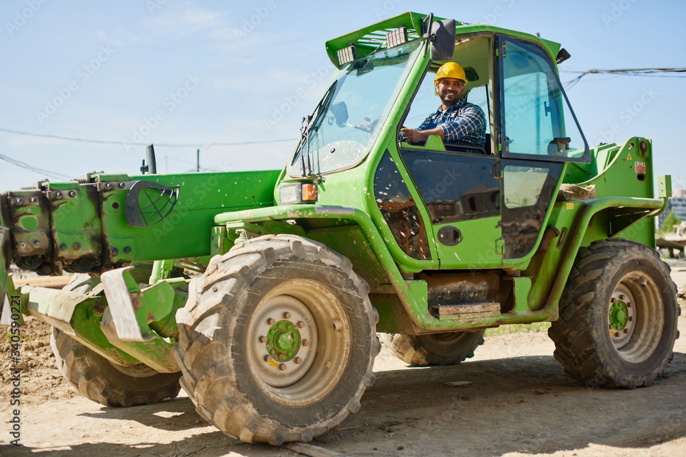 Obraz premium An engineer in uniform drives a green tractor.