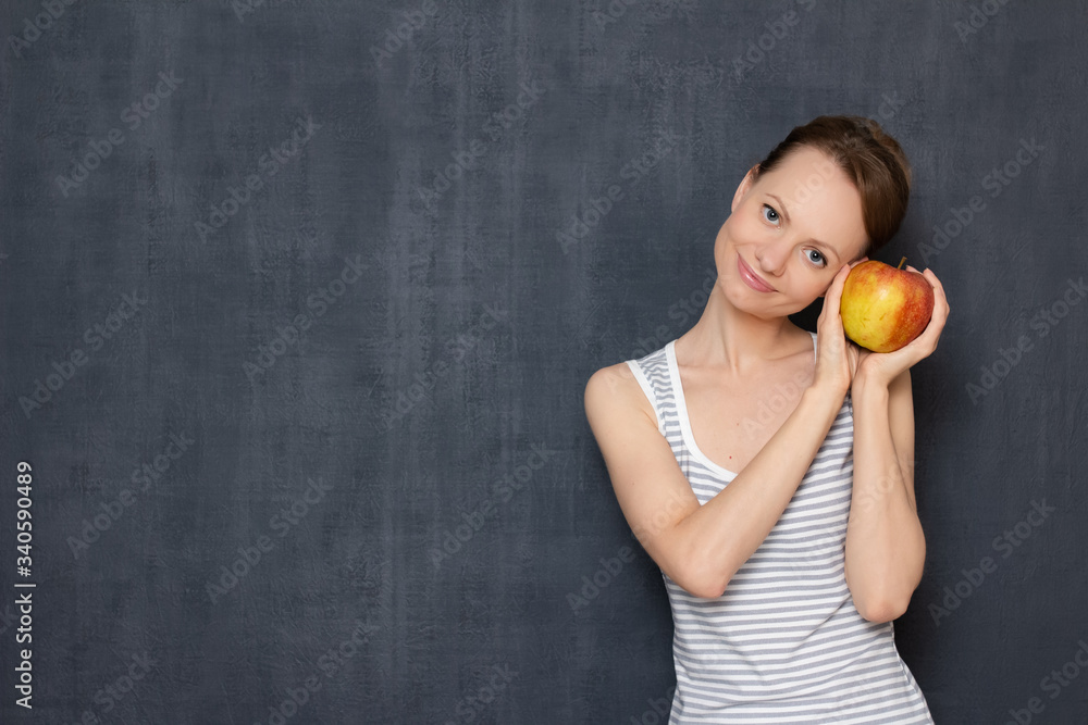 Portrait of happy girl holding ripe apple in hands and smiling Portrait of happy girl holding ripe apple in hands and smiling