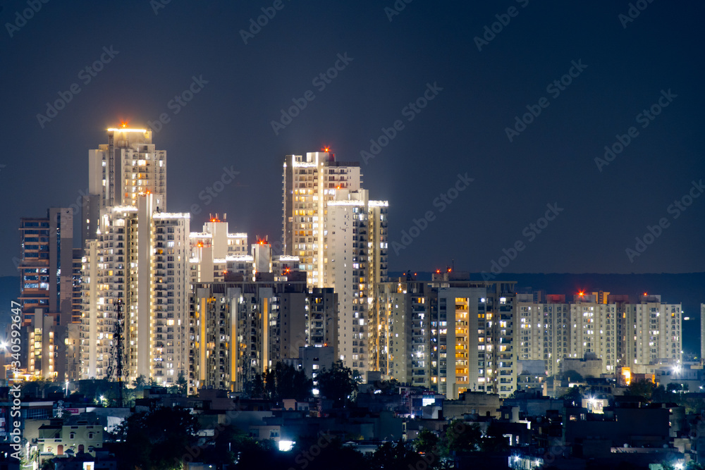 cluster of sky scraper buildings at night with golden lights shot on a pollution free night in gurgaon delhi