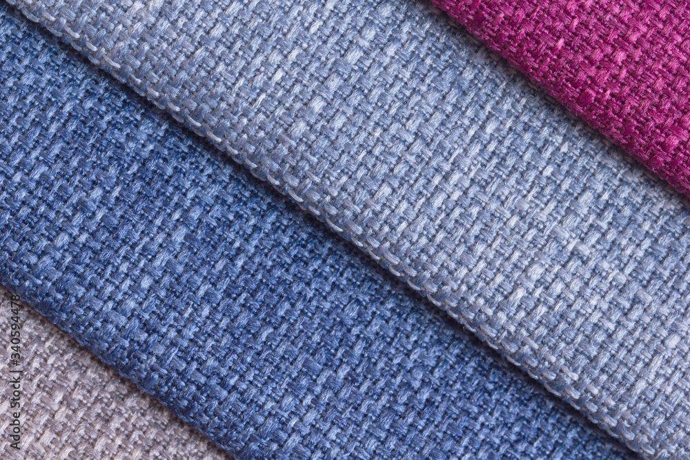A set of colored samples of upholstery fabric for furniture in stock. Background from rolls of multi-colored fabric, empty template. Fabric Gun for furniture upholstery, blue, light blue, burgundy. A set of colored samples of upholstery fabric for furniture in stock. Background from rolls of multi-colored fabric, empty template. Fabric Gun for furniture upholstery, blue, light blue, burgundy.