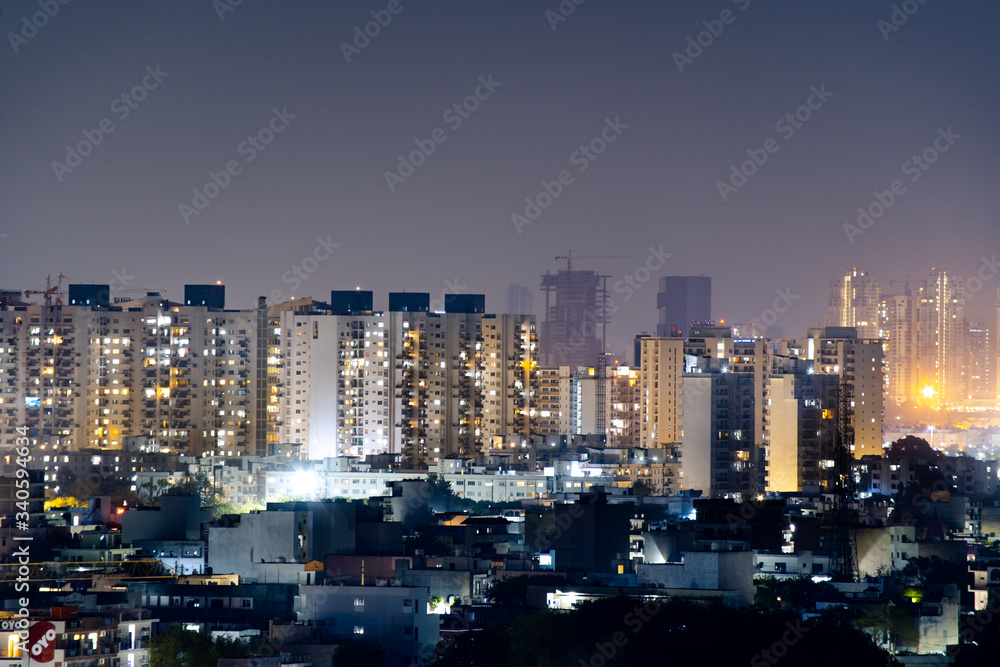 Aerial panorama shot of buildings skyscrapers with offices and residences with lights on at night