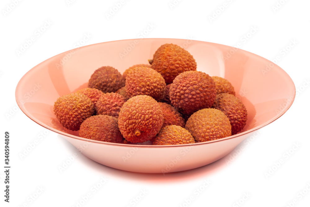 several lychee fruits lie on a coral plate on a white background, isolate several lychee fruits lie on a coral plate on a white background, isolate