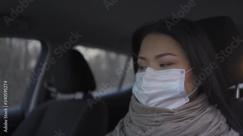 Asian female doctor going home sitting in the car fter a long shift. photo