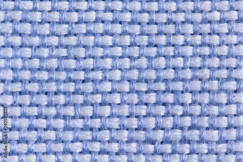 Background from the upholstery fabric of the matting for furniture in a large knit of light blue and blue threads in macro  empty template. Gunny. Large weaving of threads on the fabric.