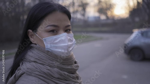 Asian woman standing in pollution mask in empty city during quarntine. photo