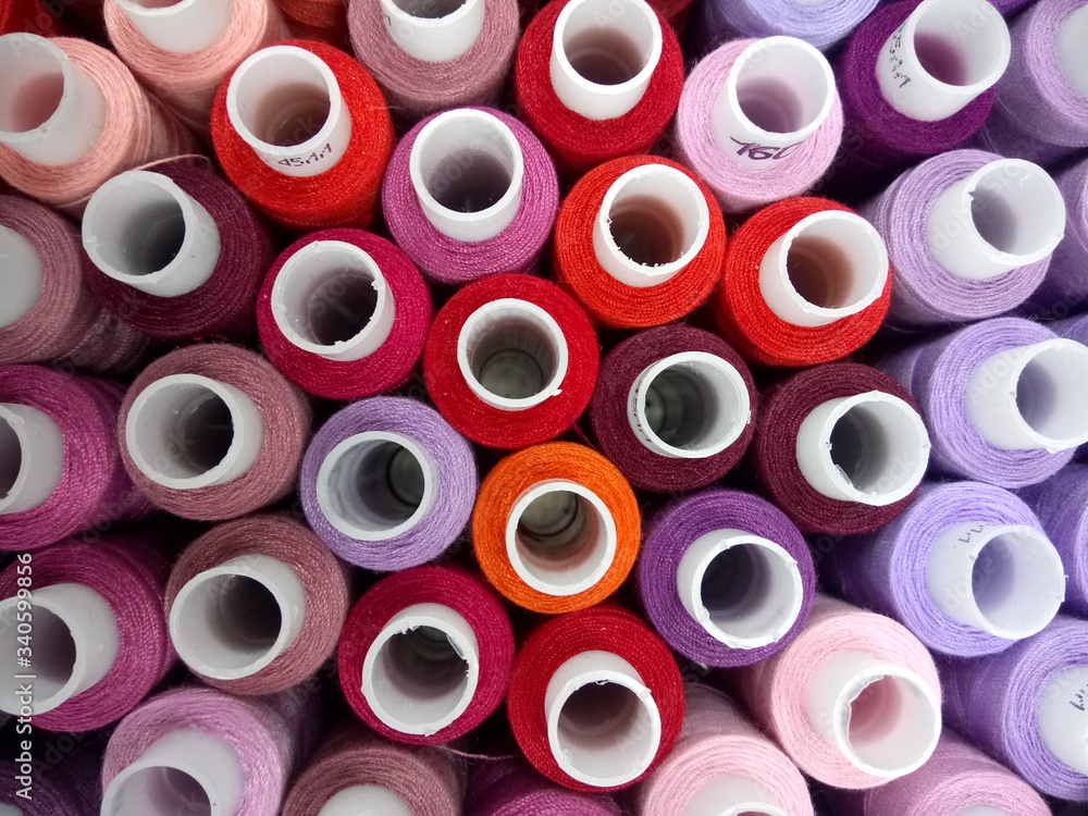 multicolored thread on bobbins close up multicolored thread on bobbins close up