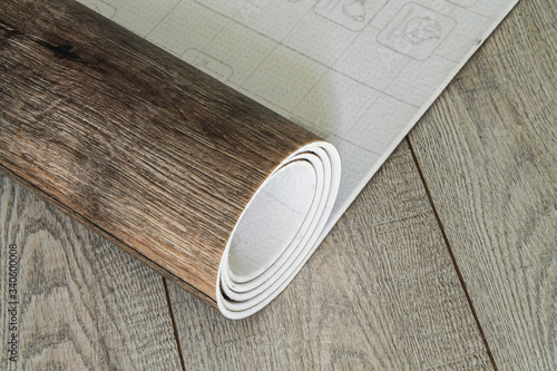 Roll of linoleum with a wood texture. Types of floor coverings.  photo