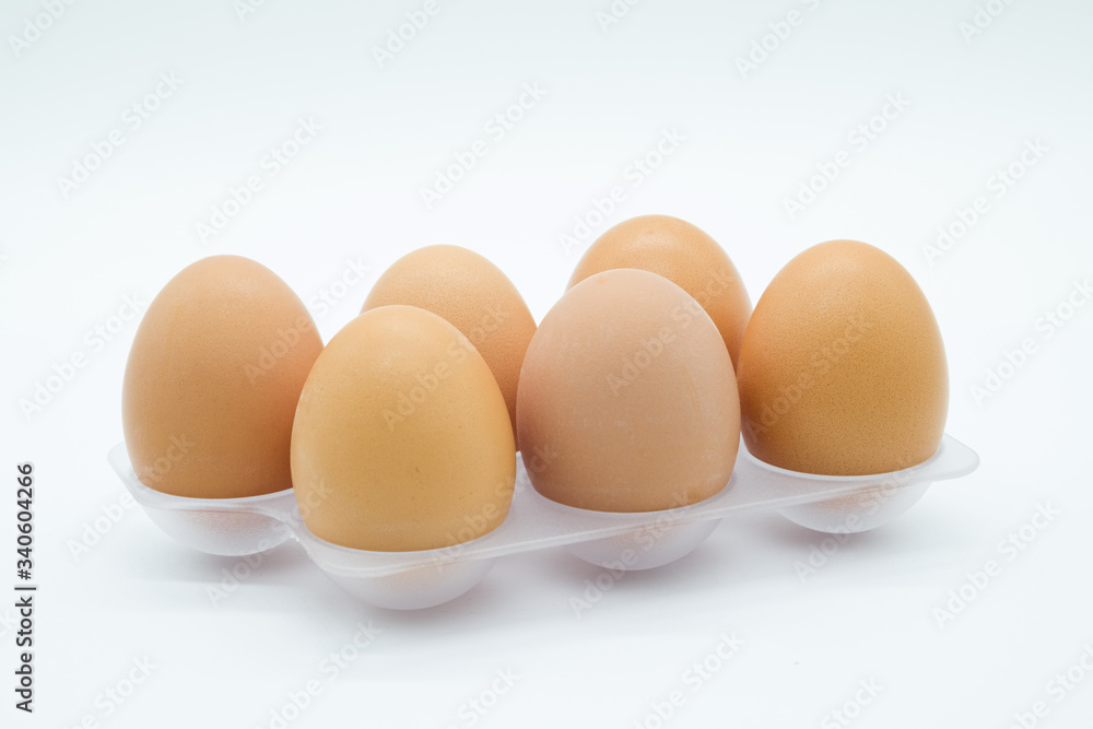 Six Eggs on a Plastic clear Tray. The eggs have clean Shells and are on a white background. Six Eggs on a Plastic clear Tray. The eggs have clean Shells and are on a white background.