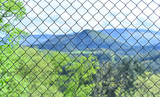 Blurred landscape behind a wire fence