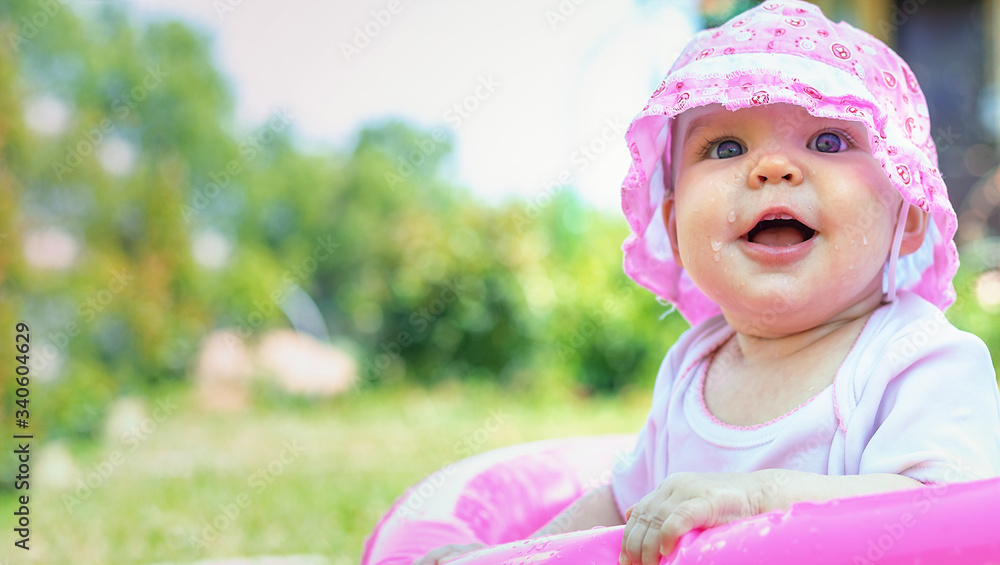 Portrait of a cute little toddler girl in pink panama in an outdoor inflatable pool in a country house in a village. Copy spase Portrait of a cute little toddler girl in pink panama in an outdoor inflatable pool in a country house in a village. Copy spase