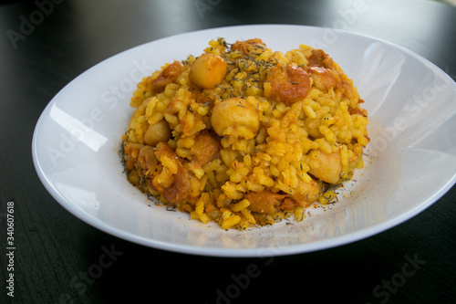 Classic valencian rice with seafood (Arroz a banda) - traditional dish of spanish cuisine on a dark wooden background.Top view.