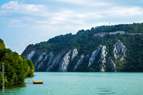 Pontoon on Danube river, landscape with water and mountains, Cazanele Dunarii, Romania. © Sulugiuc