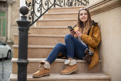 Photo of young tourist girl exploring streets of Baku. Moody photos of teenager girl visiting old city and taking photos of the city