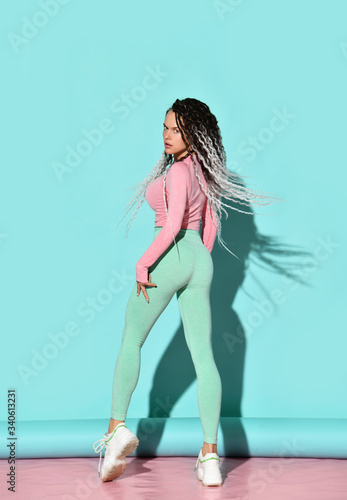 Fotografia Young beautiful girl with dreadlocks hairstyle in sexy sportswear and sneakers s