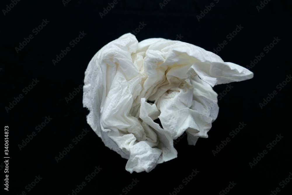 Paper handkerchief, use and throw away.  Close up, crumpled up,  isolated on black background. Use only once. Contagion, Corona, Corvid 19 