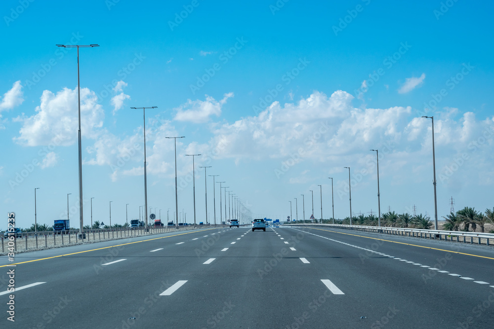 a straight view of highway through desert in Abu Dhabi, UAE