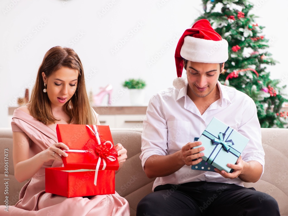 Young couple celebrating christmas at home Young couple celebrating christmas at home